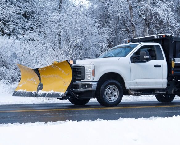 Truck with a Yellow snow plow in the winter